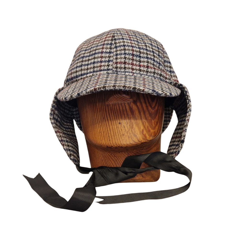 A classic deerstalker hat with a grey,  brown, black, and white houndstooth pattern, displayed on a wooden mannequin head against a plain white background. Flaps down