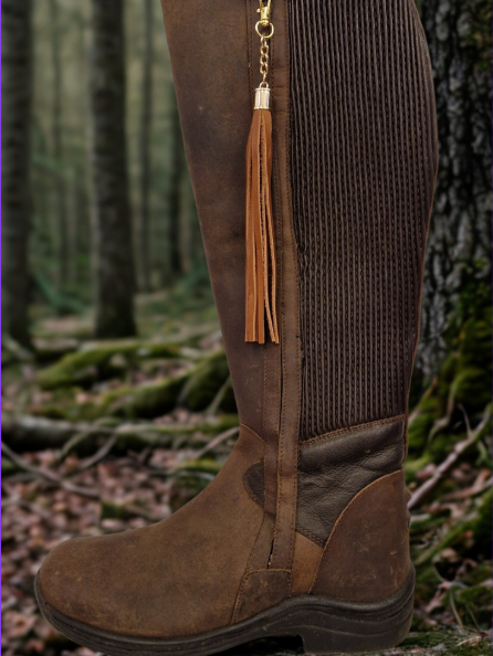 Handmade leather boot tassel on boot in the woods